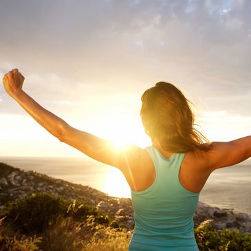 Athletic woman stretching toward sun