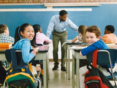 Students looking at the camera in a classroom.