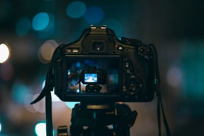 DSLR camera on a tripod capturing a blurry night scene.
