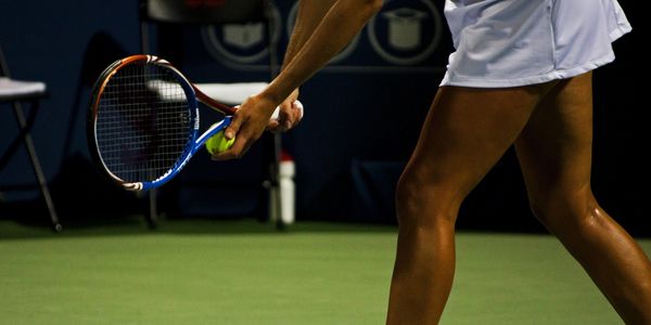 Tennis player preparing to serve on a court.