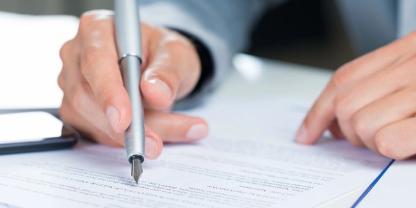 A person pointing a pen at a document