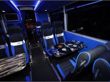 Interior of a modern bus with blue ambient lighting and comfortable seating.