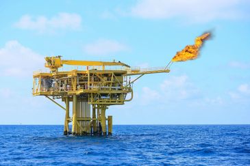 Offshore oil platform flaring gas over the ocean.