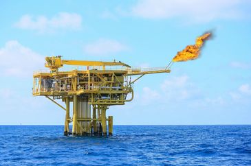 Offshore oil platform flaring gas over the ocean.