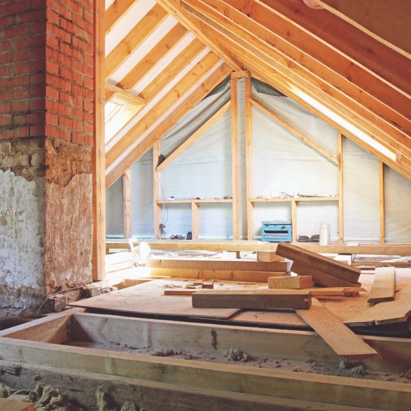 Attic under construction with wooden beams and insulation.