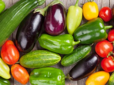 Colorful fresh vegetables including eggplants, peppers, tomatoes, and cucumbers.