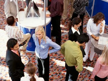 Professionals networking and conversing at a business event or conference.