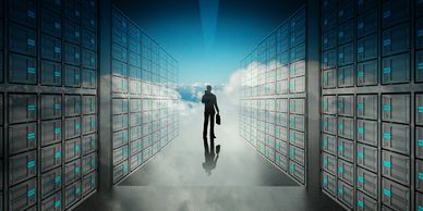 Man in a server room walkway approaching clouds as a reference to IT Infrastructure Optimisation