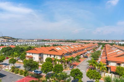 Aerial view of a suburban neighborhood with rows of houses and orange roofs.