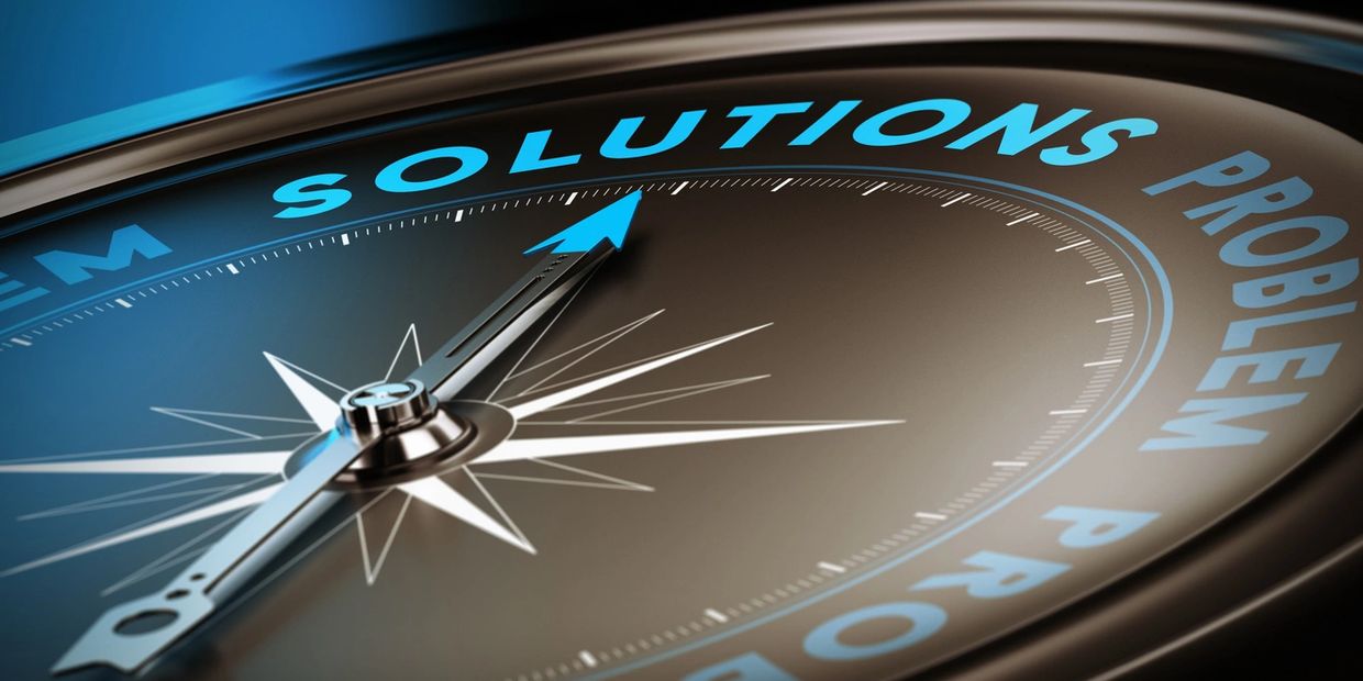 Close-up of a compass pointing to 'Solutions' instead of 'Problem'.
