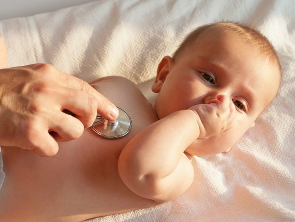 Doctor checking baby with stethoscope.