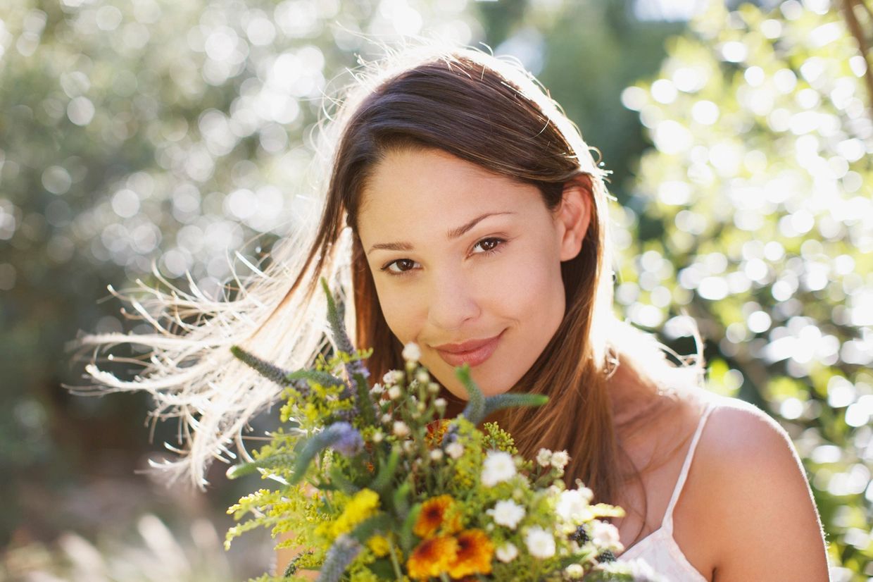 A woman taking a flower and looking on the head