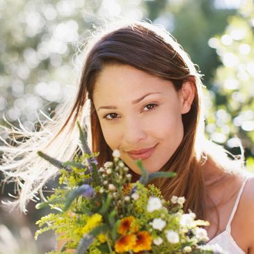 A girl smelling garden flowers