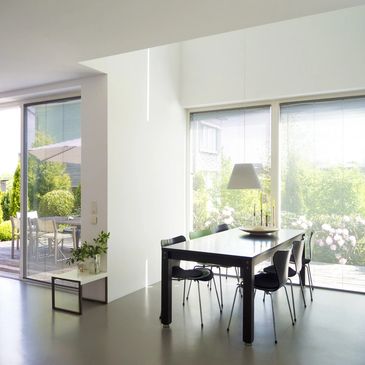 dining area of a home with tall windows and glass door