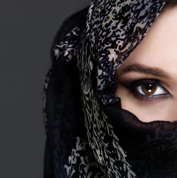 Close-up of a woman's eye with decorative black scarf.