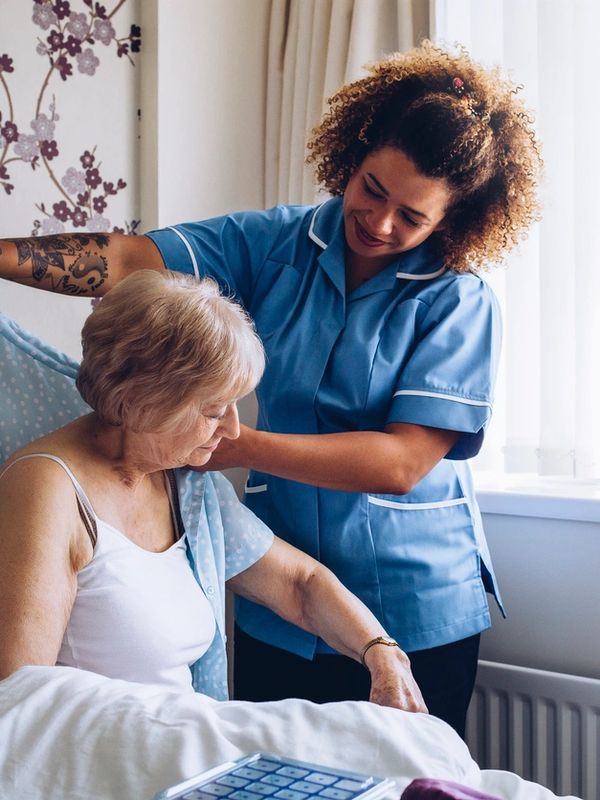 an elderly woman receiving help