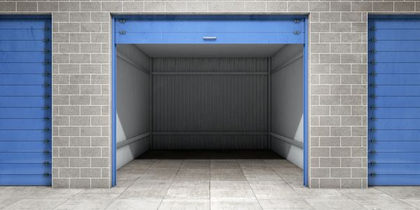 Empty blue garage door open in a brick building.