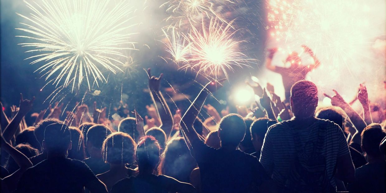 Crowd enjoying vibrant fireworks display at night.