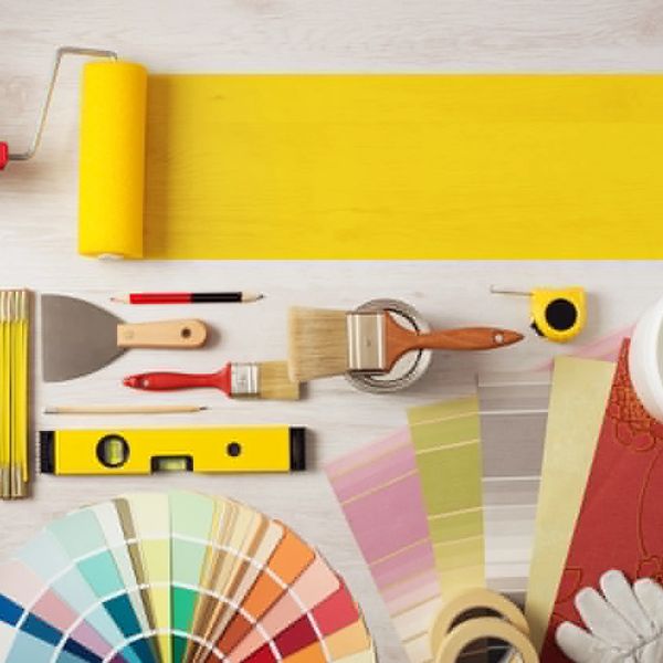 Various painting and decorating tools arranged neatly on a light surface.