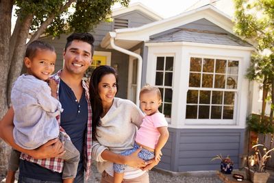 Image of a happy family in front of their well-maintained home