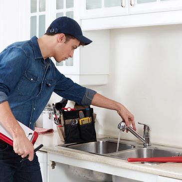 A man checking tap water in a kitchen