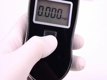 A hand in a white glove holding a digital device showing 0.000 mg/L.