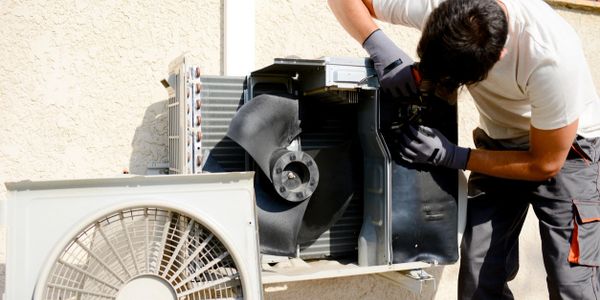 Worker Repairing an air conditioning unit for maintenance.