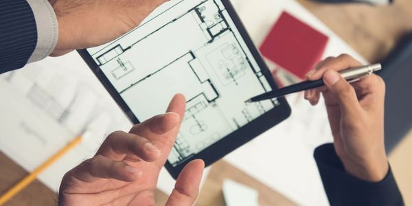 Person reviewing building plans on a tablet.