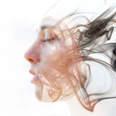 Profile of a woman's face blending with swirling smoke patterns.