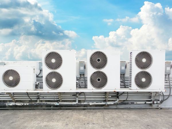 Outdoor air conditioning units lined up under a bright blue sky.