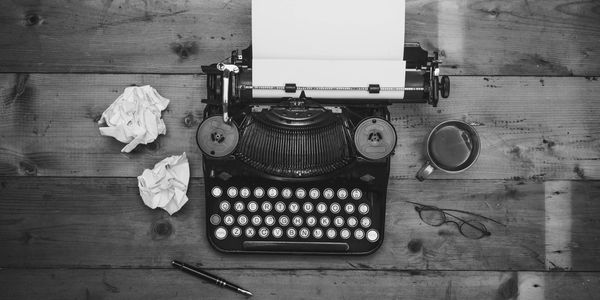 Typewriter with two pieces of crumpled paper on the left