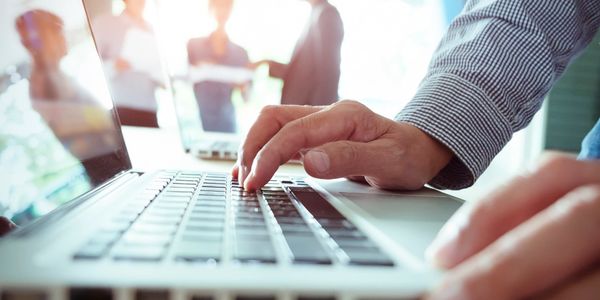 Close-up of a Funnel Analytics team member working on digital marketing strategies on a computer.