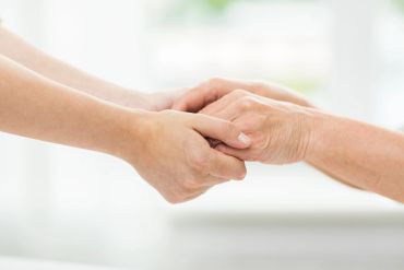 Two people holding hands gently.