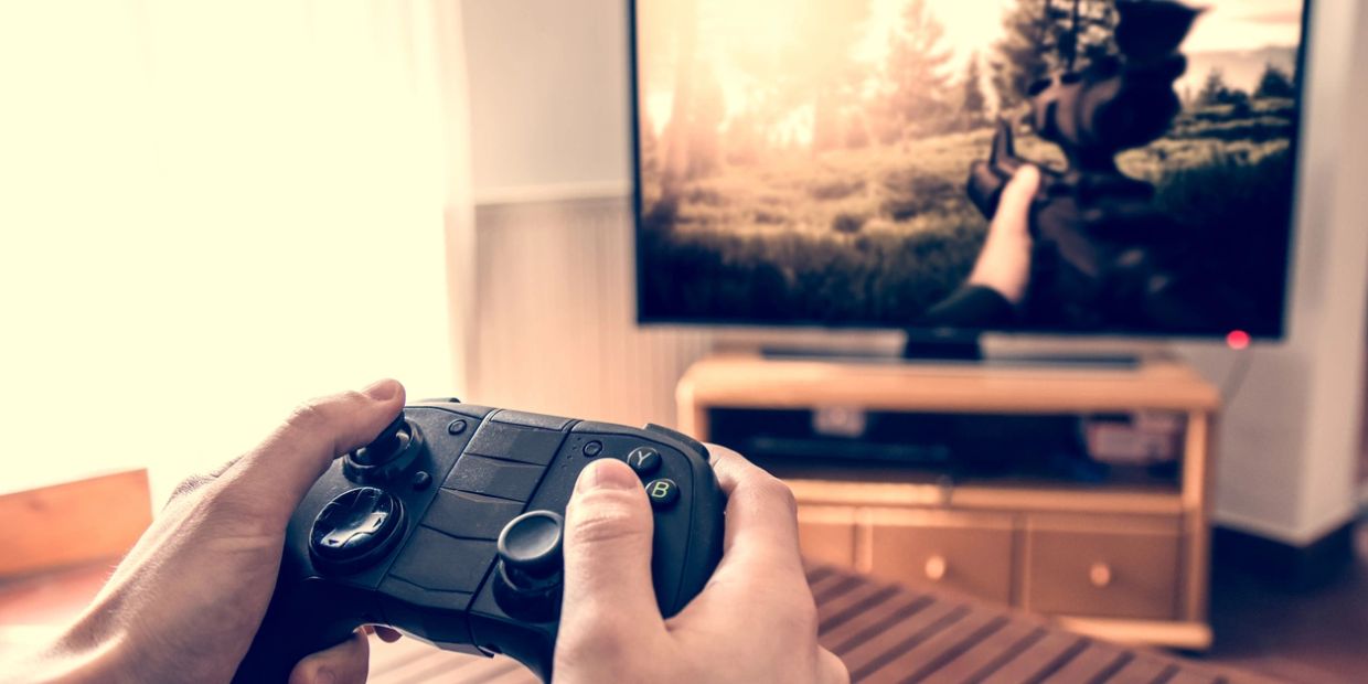 Person playing a shooting game with a controller.