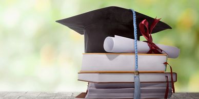 a graduation cap with a diploma on top of books