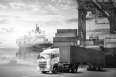 Shipping Port with Vessel in dock, containers stacked and container on Truck ready for transport.