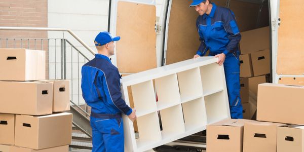 Movers taking a bookcase out of a moving van