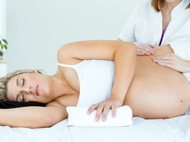 Pregnant woman receiving a massage while lying down.