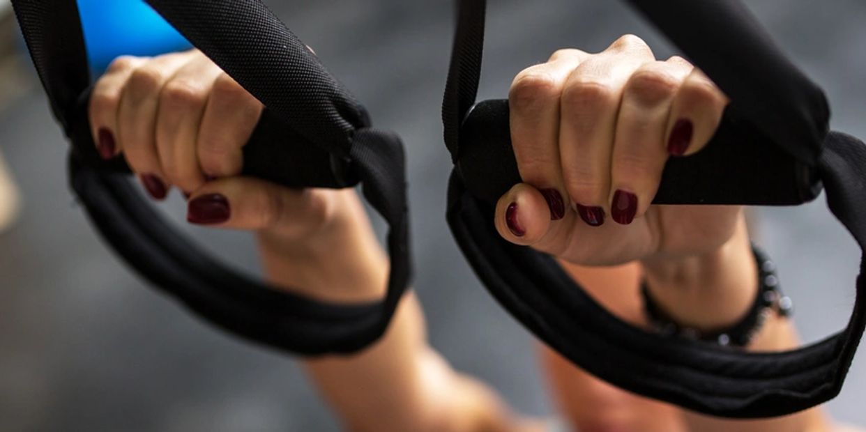 womans hands in pilates rings