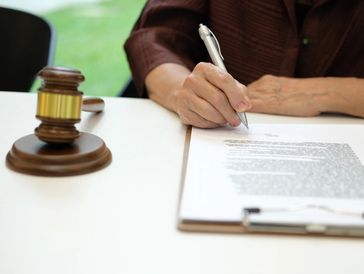 Hands signing official tax documents.