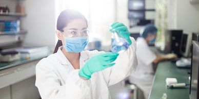 Researcher in lab coat examining a sample