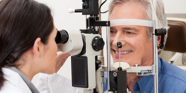 A physician using a medical machine to look into a patient's eye.