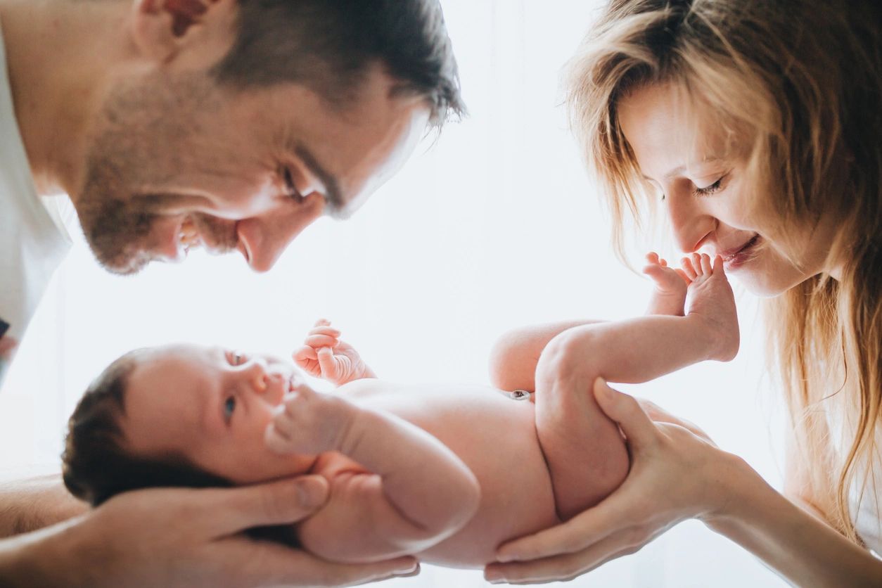 New parents gush over their newborn after postpartum education with their postpartum doula.