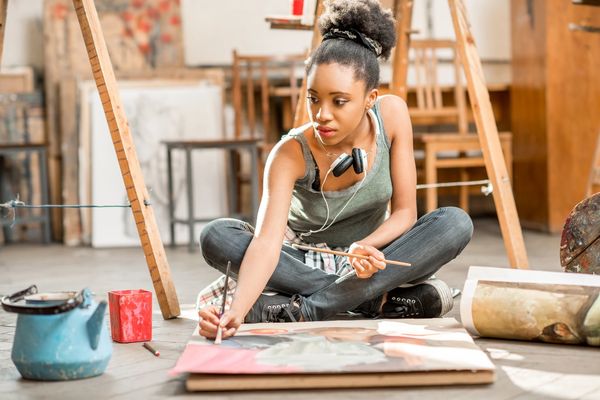 Young woman painting with focus in an art studio.