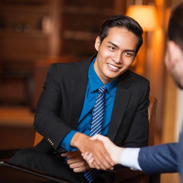Two businessmen shaking hands during a meeting.