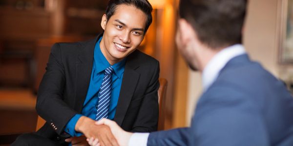 Photo of two suited people shaking hands