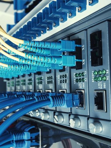 Network cables plugged into a switch for data transmission.