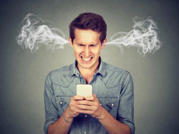Frustrated man with steam coming from his ears while using a smartphone.