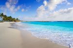 Tropical beach with clear blue water and white sand.