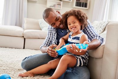 Father playing toy guitar with young daughter